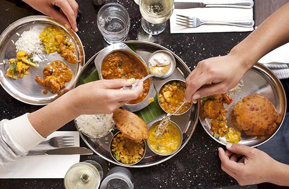 A group of people enjoying Indian cuisine at a table.