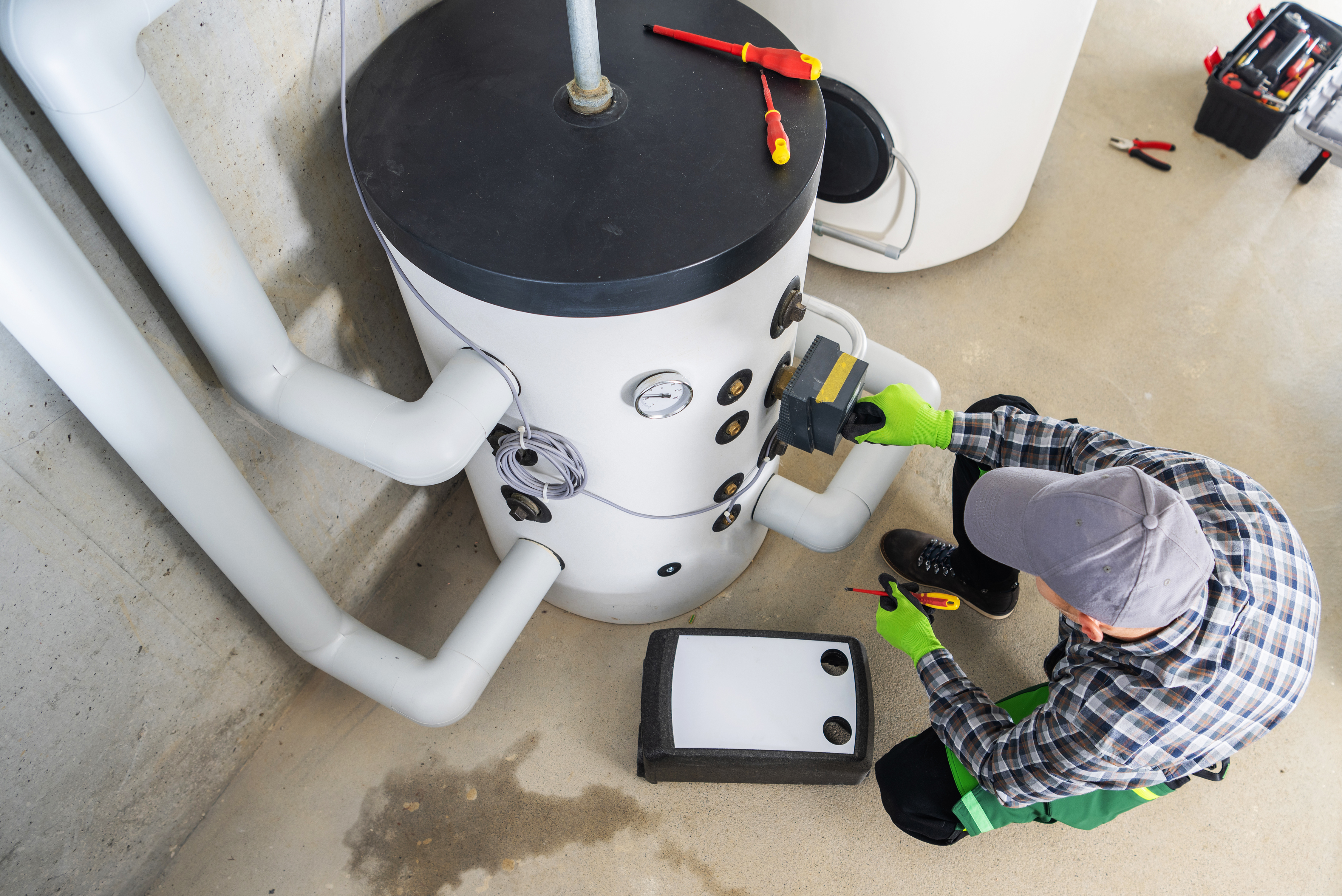 A plumber performing maintenance of a water heater.