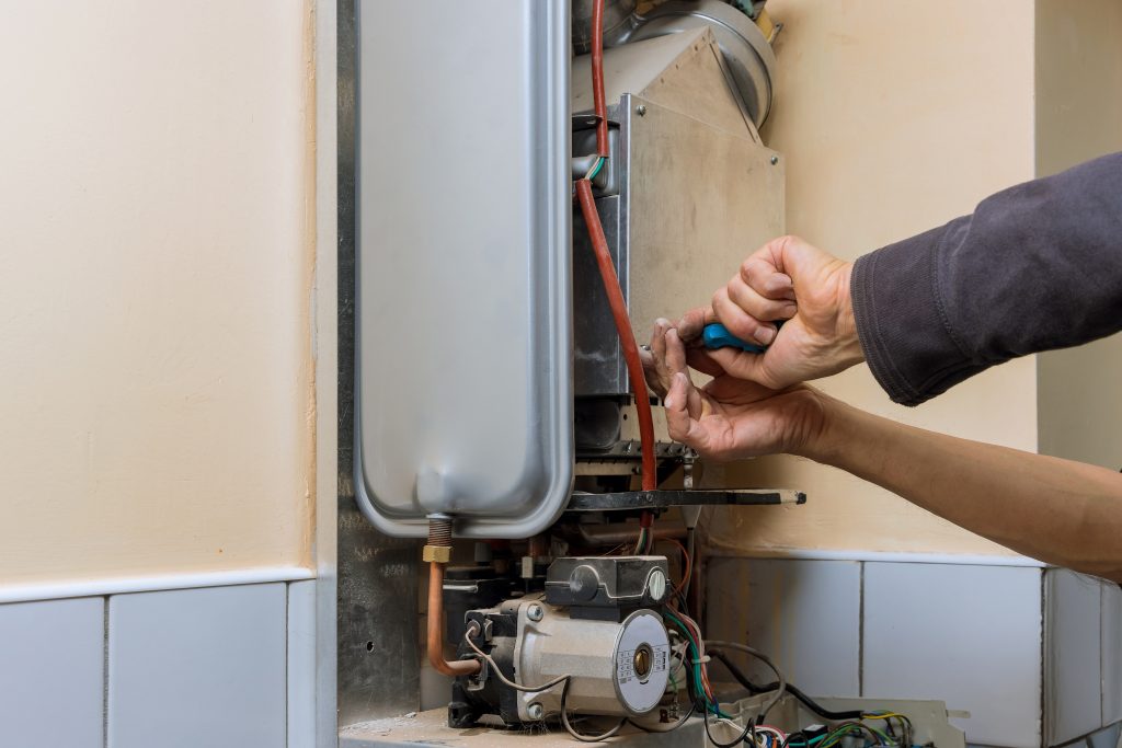 \Professional plumber fixing a malfunctioning water heater.