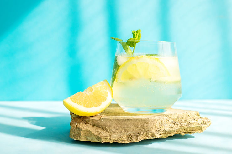 A detox drink with lemon, water, and a sprig of mint.