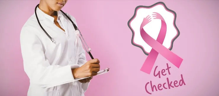 A doctor making notes and standing next to the breast cancer awareness ribbon that reads, "Get Checked."
