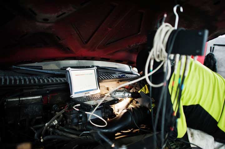 Technician assessing vehicle damage with diagnostic tools