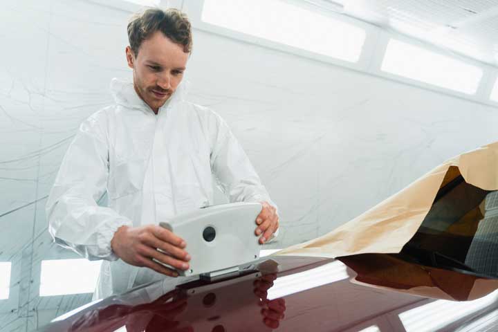 Technician using paint-matching technology to ensure perfect color match