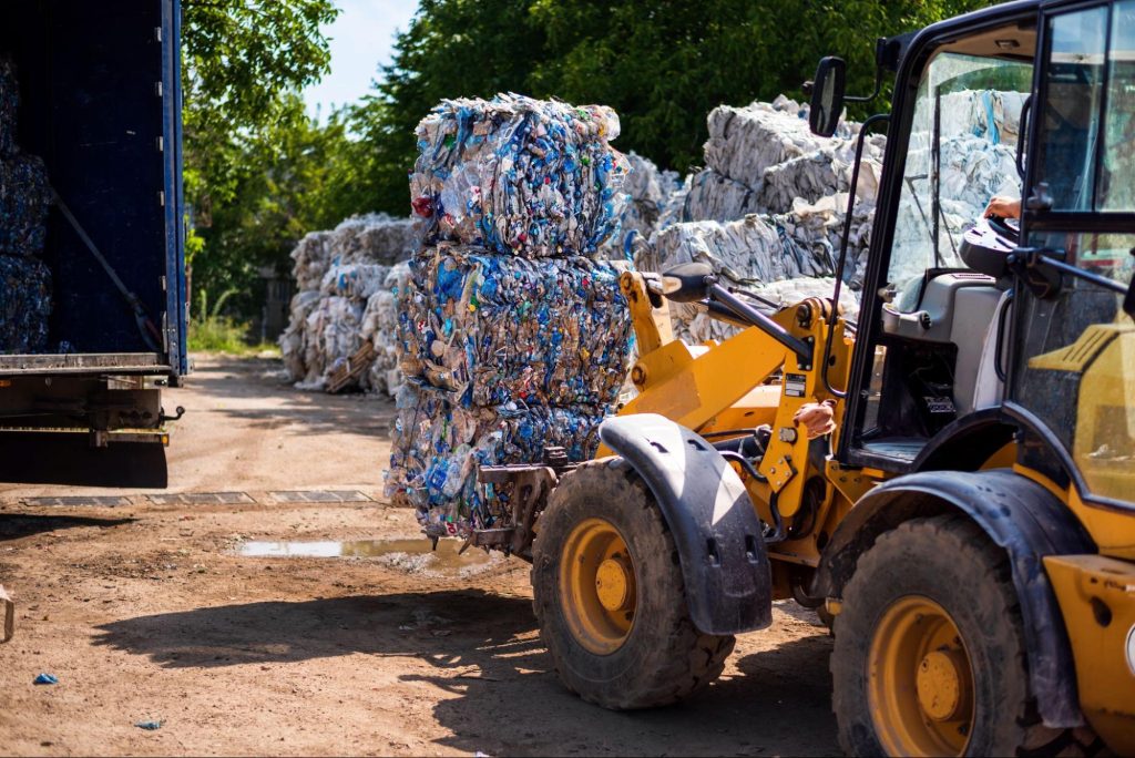 Recyclable material on a construction site next to an excavator.