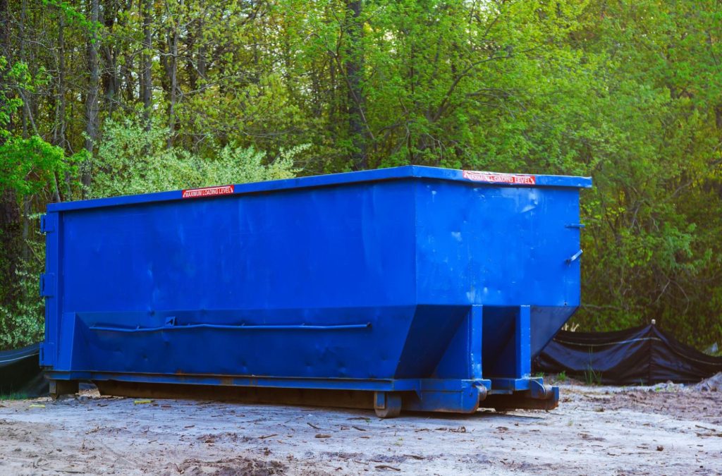 Dumpster with greenery around. 